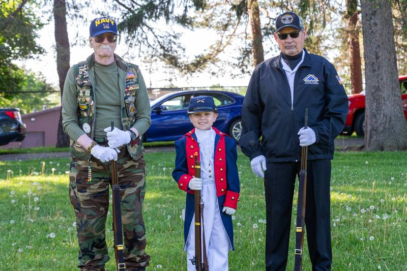 young boy dressed in war regalia with honorguard