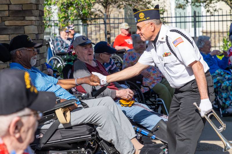 a buglar paying respects to a veteran druing the memorial day services.