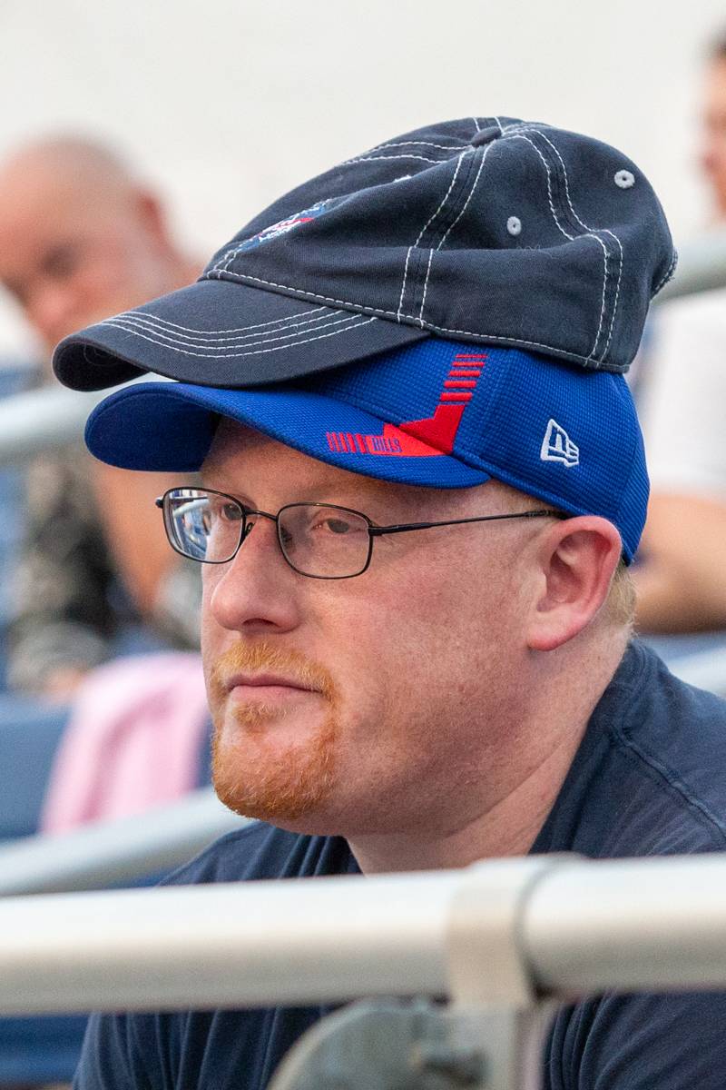 Extra hat for dad by his son during the game.  Photo by Steve Ognibene