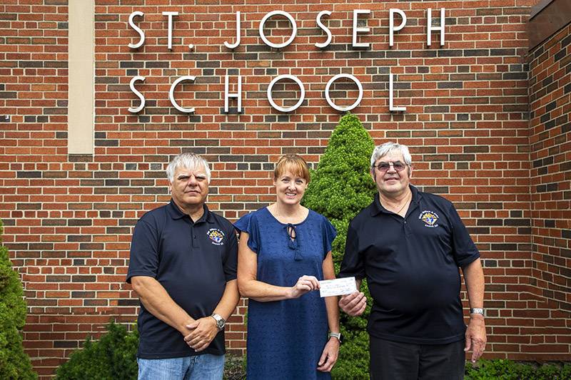 K of C members Tom Trescott and Grand Knight Ken Mullen present a scholarship check to Principal Karen Green of St. Joes School Photo Steve Ognibene