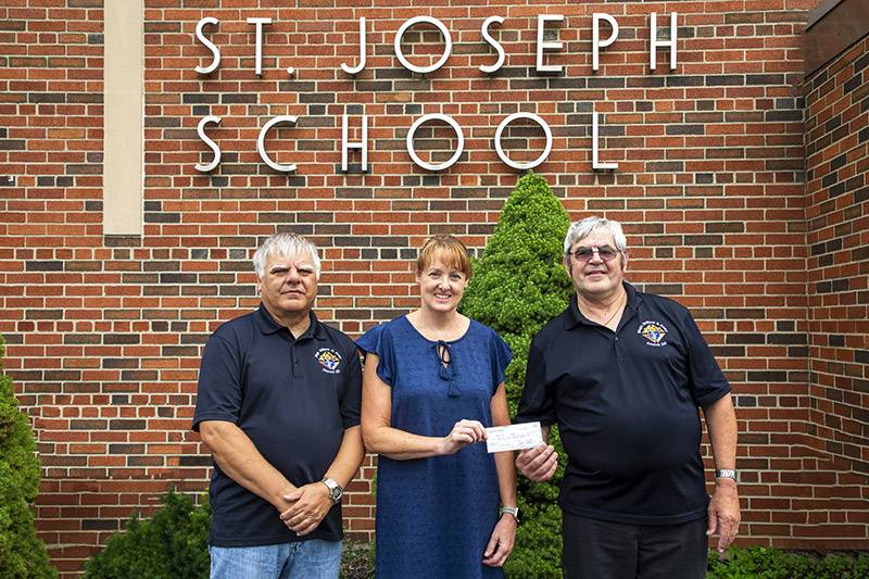 K of C members Tom Trescott and Grand Knight Ken Mullen present a scholarship check to Principal Karen Green of St. Joes School  Photo Steve Ognibene