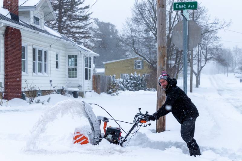 A man clearing his sidewalk with his snowblower on East Avenue.  Photo by Steve Ognibene