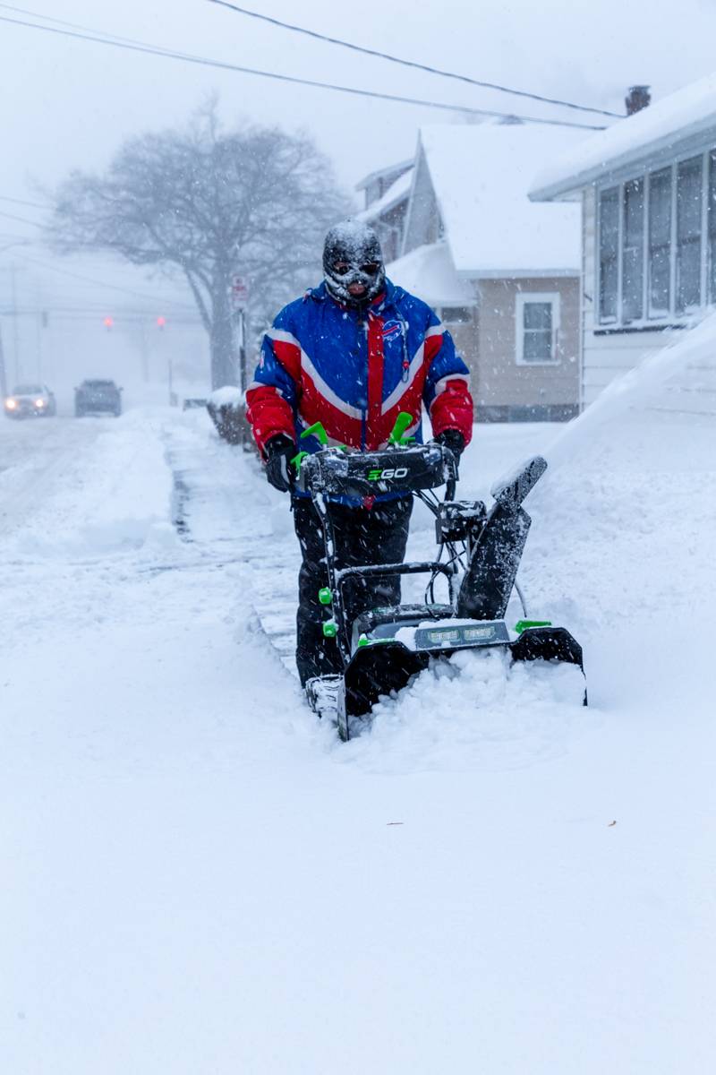 A Buffalo Bills fan testing out his electric snowblower for the first time.  Photo by Steve Ognibene