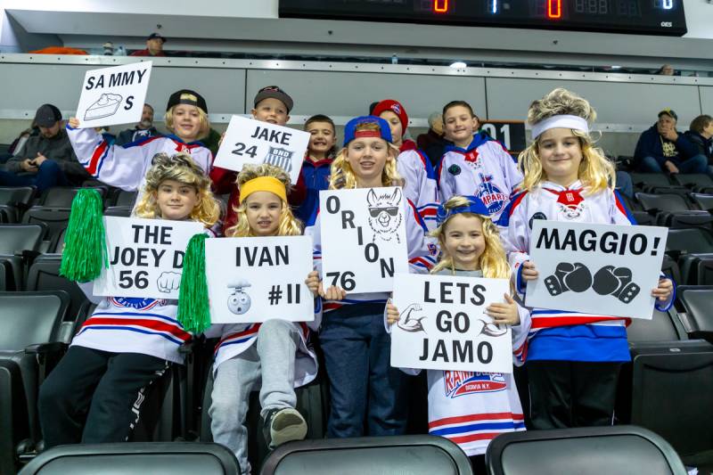 Young hockey fans of BND United showing support with wigs and signs.  Photo by Steve Ognibene