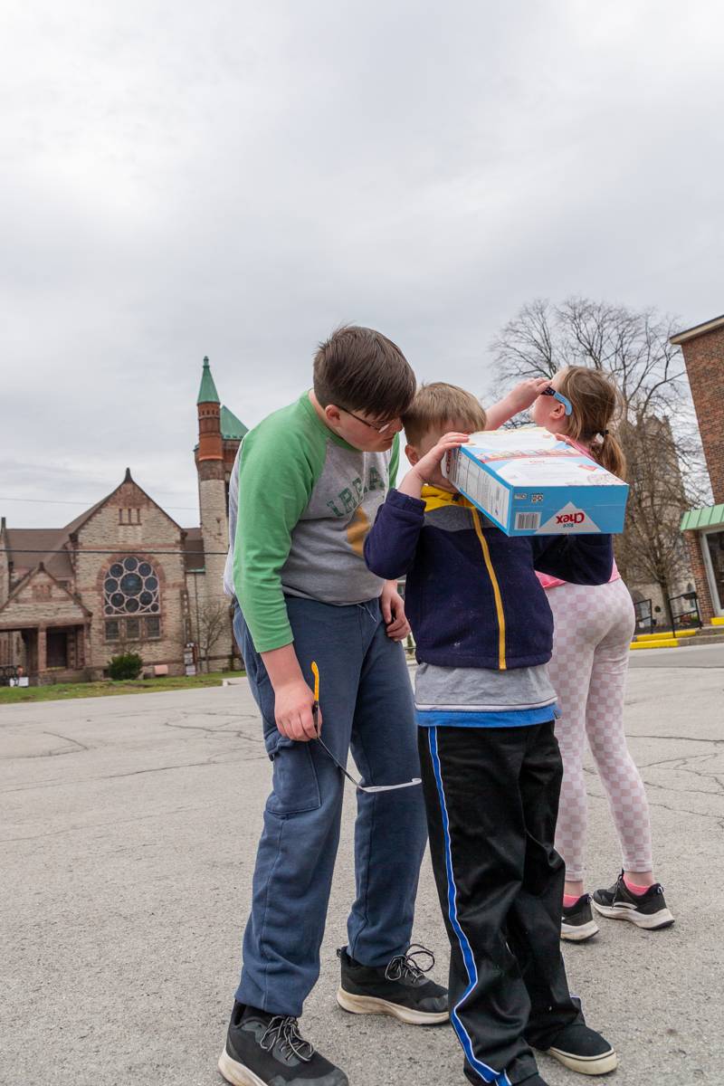 Kids using a pinhole viewer to see the partial eclipse at 2:43pm  Photo by Steve Ognibene