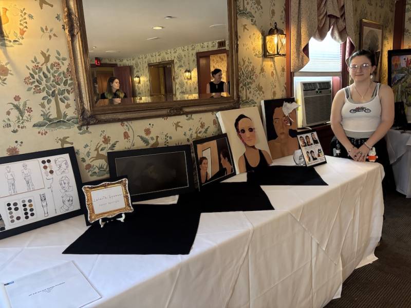 Lilaith Spencer stands beside art representing a time of struggle.